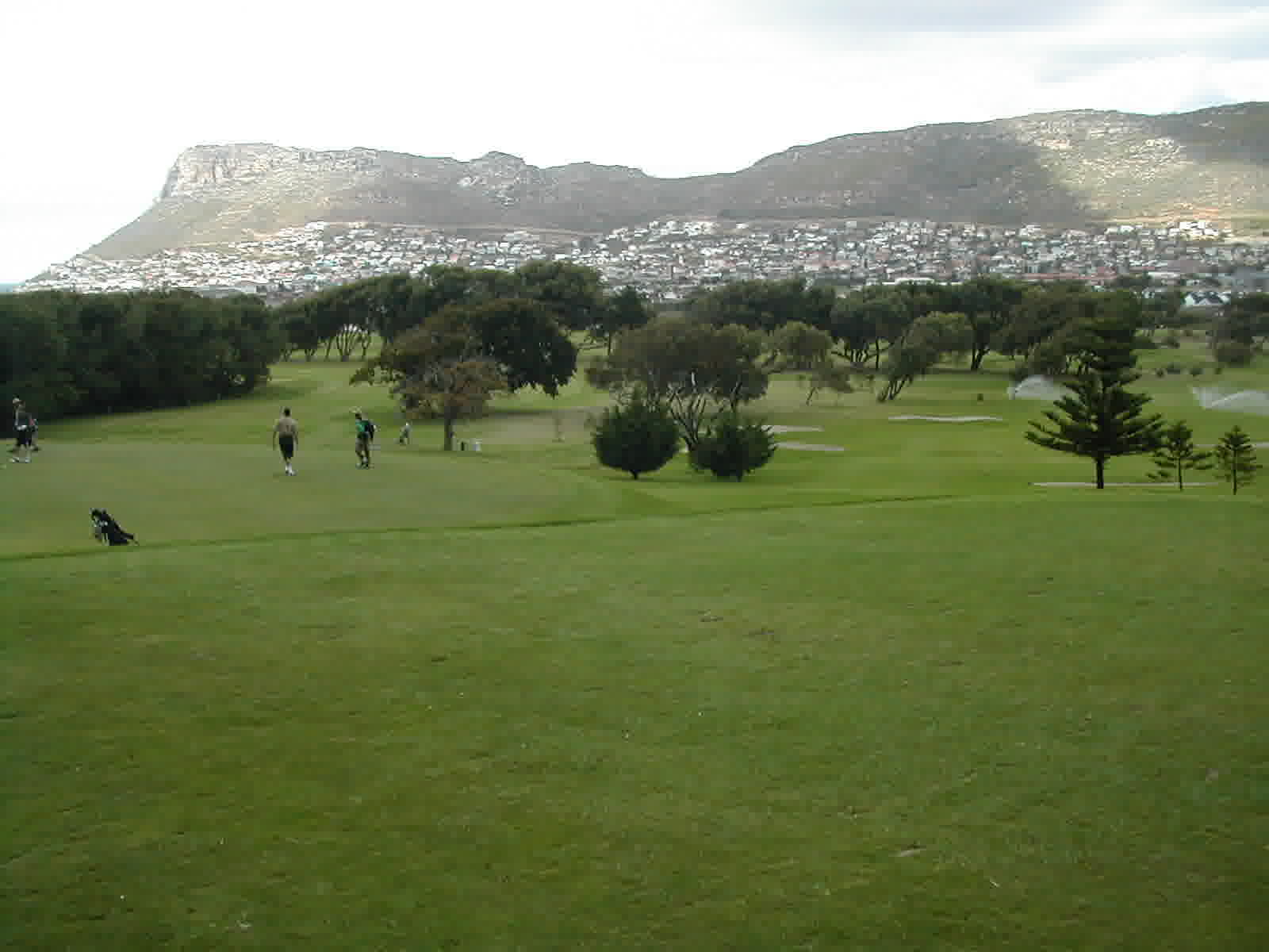 Golfers on a fairway with a mountain backdrop in South Africa